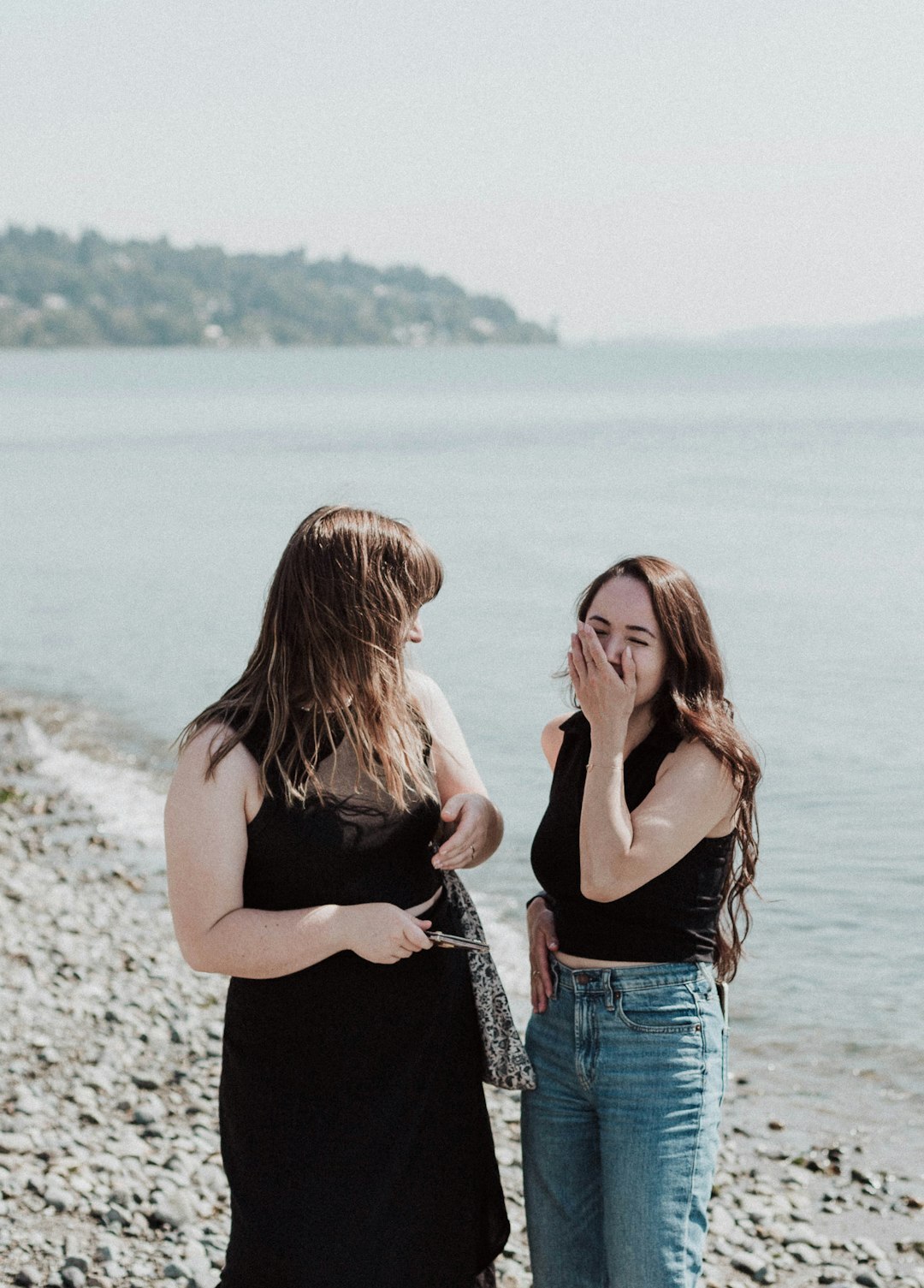 Two friends laughing together while talking outdoors